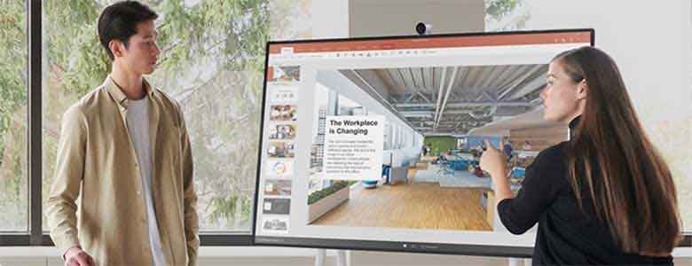 Een man en vrouw werken met een Surface Hub 2S