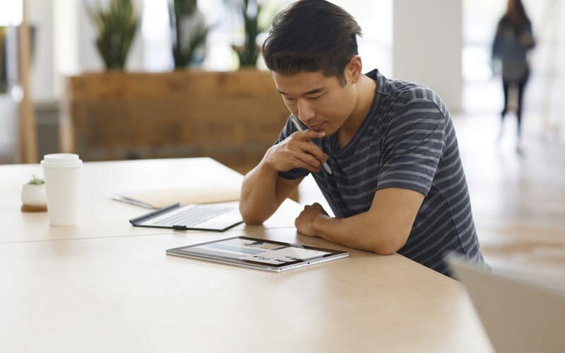 Een jonge man werkt op een 2-in-1- HP notebook device
