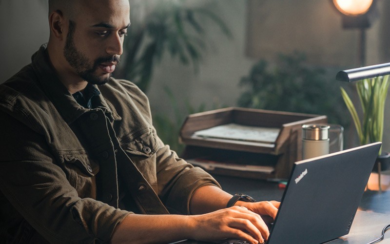 Een man werkt op een ThinkPad laptop