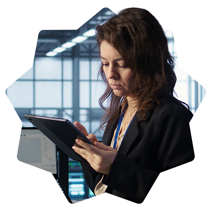 Woman sitting at a desk holding a tablet