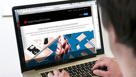 Een man werkt op zijn laptop met Adobe Teams