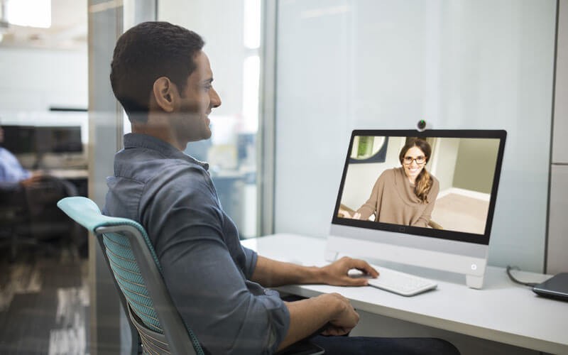 Een man in een Cisco WebEx vergadering ziet zijn vrouwlijke collega op een beeldscherm