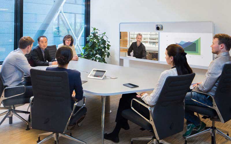 Werknemers in een vergadering met Cisco WebEx op een groot scherm