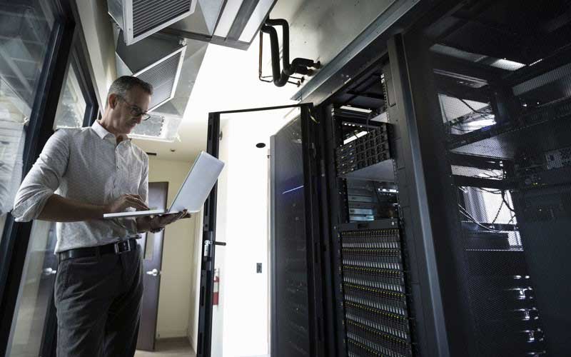Een Cisco engineer met zijn laptop in een datacenter