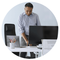 Een man werkt staand aan zijn bureau met een Microsoft Surface laptop