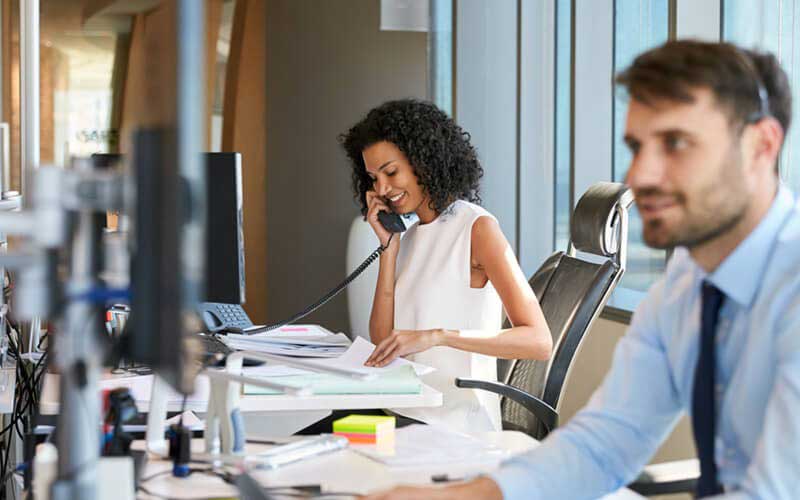 Een vrouw telefoneert op haar werkplek