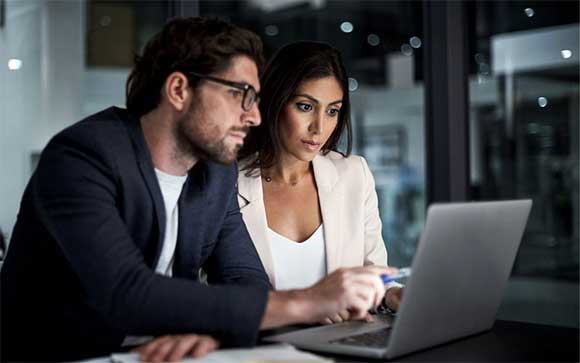 Een man en vrouw bekijken  VMware-oplossingen op hun laptop