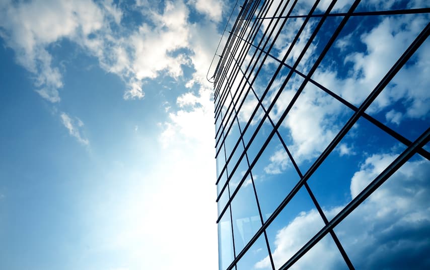 Gebouw met de lucht erboven weerspiegeld in de ramen