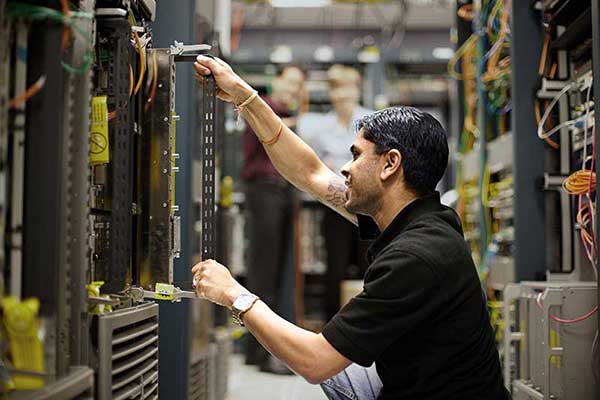 Een medewerker installeert servers in een datacenter