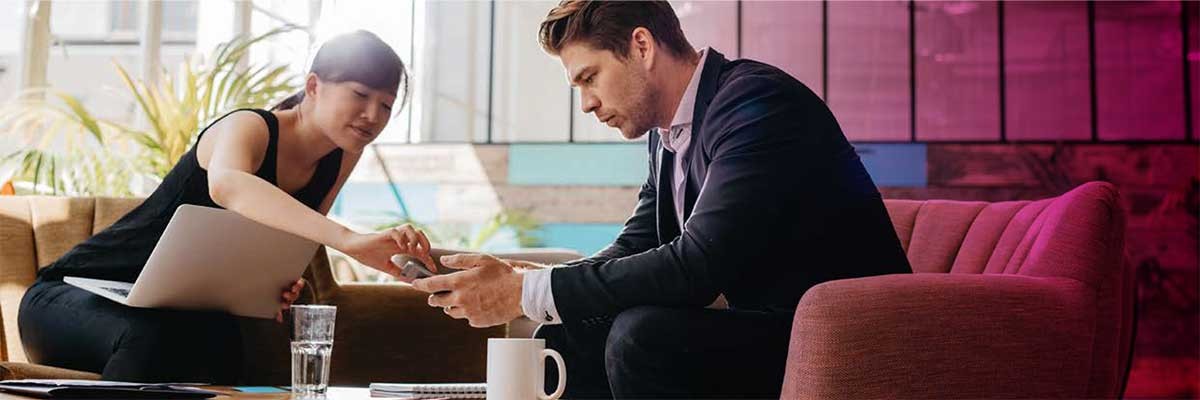 Een vrouwlijke en mannelijke werknemer bekijken de Windows 10 Migratie Checklist