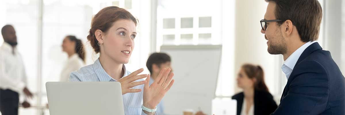 Een man en vrouw zijn in gesprek op kantoor