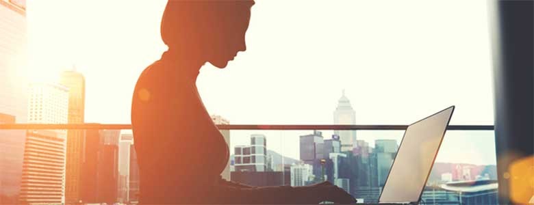 Een vrouw werkt op haar laptop in een modern kantoorgebouw