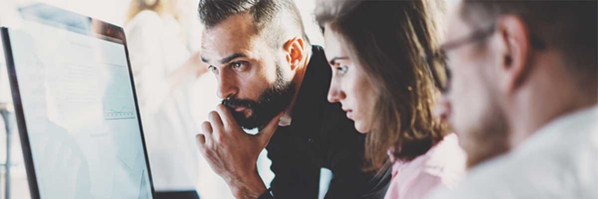 Drie collega's kijken op een monitor