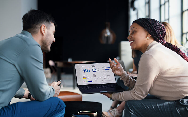 Twee collega’s van Insight die samenwerken aan gegevens over de AI-transformatie en projectstatistieken, weergegeven op een dashboardscherm.