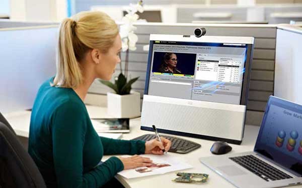 Een vrouw schijft terwijl ze naar een beeldscherm kijkt