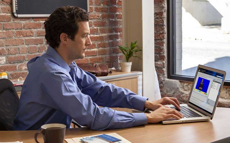 Een man gebruikt Outlook op zijn laptop