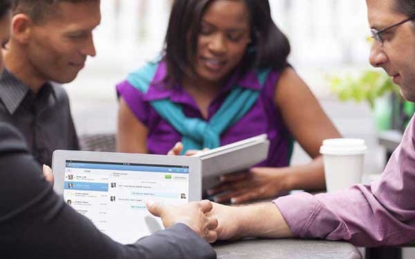 Werknemers aan een tafel lezen op hun tablet