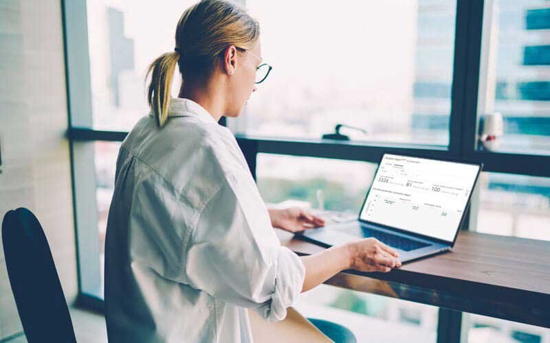 Een vrouw gebruikt haar laptop op kantoor