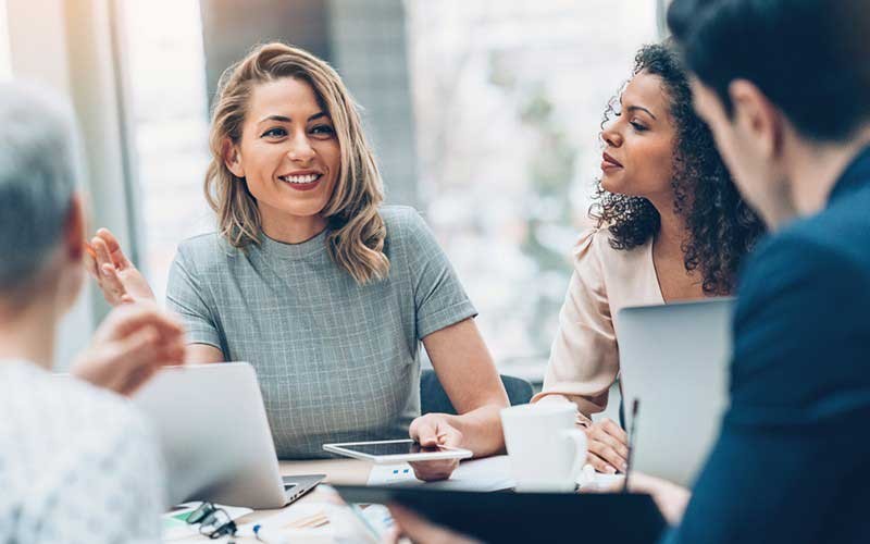 Een vrouw lacht tijdens een meeting