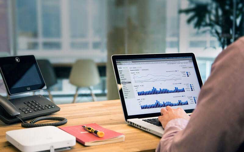 Een m an heeft een Meraki dashboard op zijn laptop