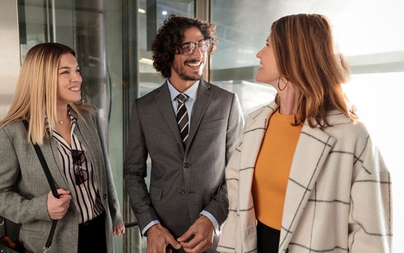Twee vrouwen zijn in gesprek met een mannelijke collega