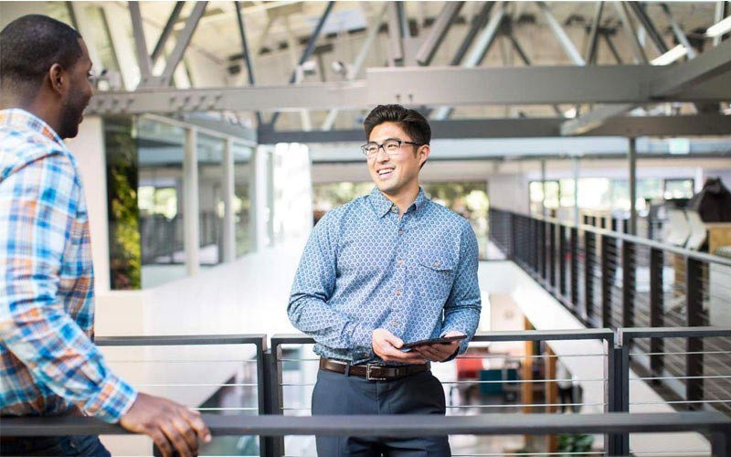 Zakelijke man die glimlacht terwijl hij het tablet-apparaat vasthoudt