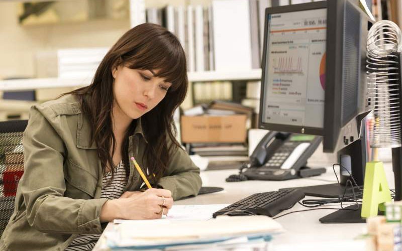 Vrouw die de kantoorruimte beheert met behulp van desktop- en managementsoftware