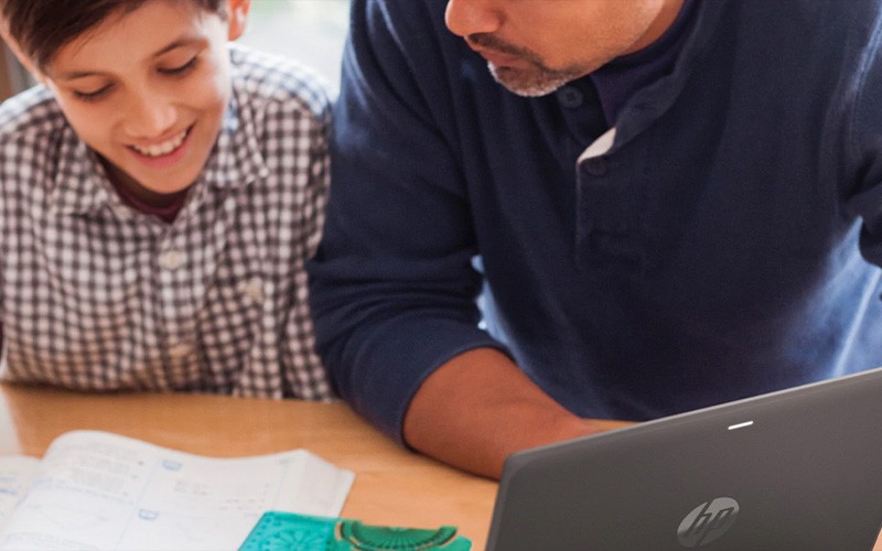 Transformeer endpoints Een vader en zoon gebruiken een HP laptop