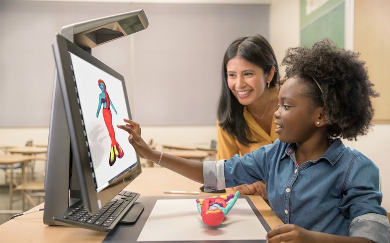 Een meisje en haar lerares tekenen op een HP All-In-One desktop