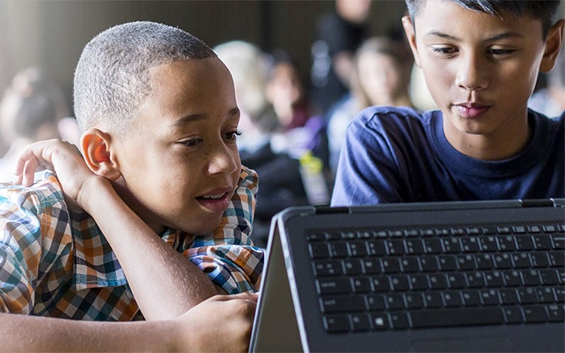 Twee jonge jongens werken op een HP 2-in-1 laptop