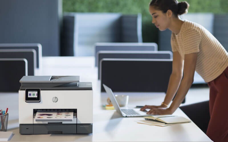 Een vrouw gebruikt een HP OfficeJet all-in-one-printer
