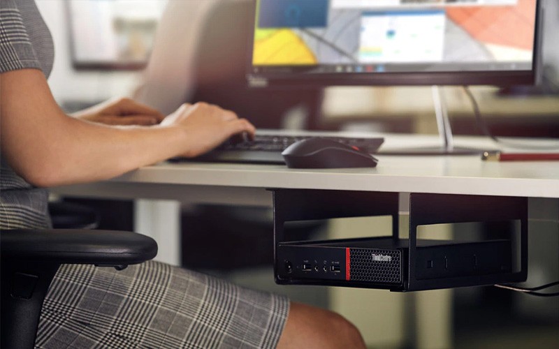 Een vrouw heeft een ThinkCentre M Serie onder haar bureau