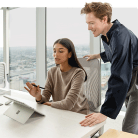 Een vrouw met collega werkt op een Surface Pro