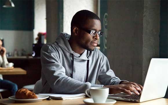 Schakel Werken op afstand in met VMware Een man werkt op zijn notebook met VMware