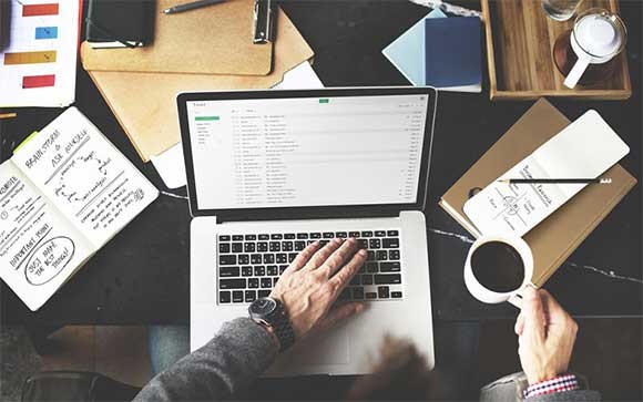 Schalen voor een externe digital workspace Een man drinkt koffie achter zijn MacBook