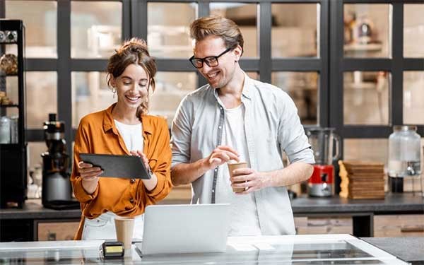 Verbeter uw digitale strategie Twee collega's met een tablet en laptop